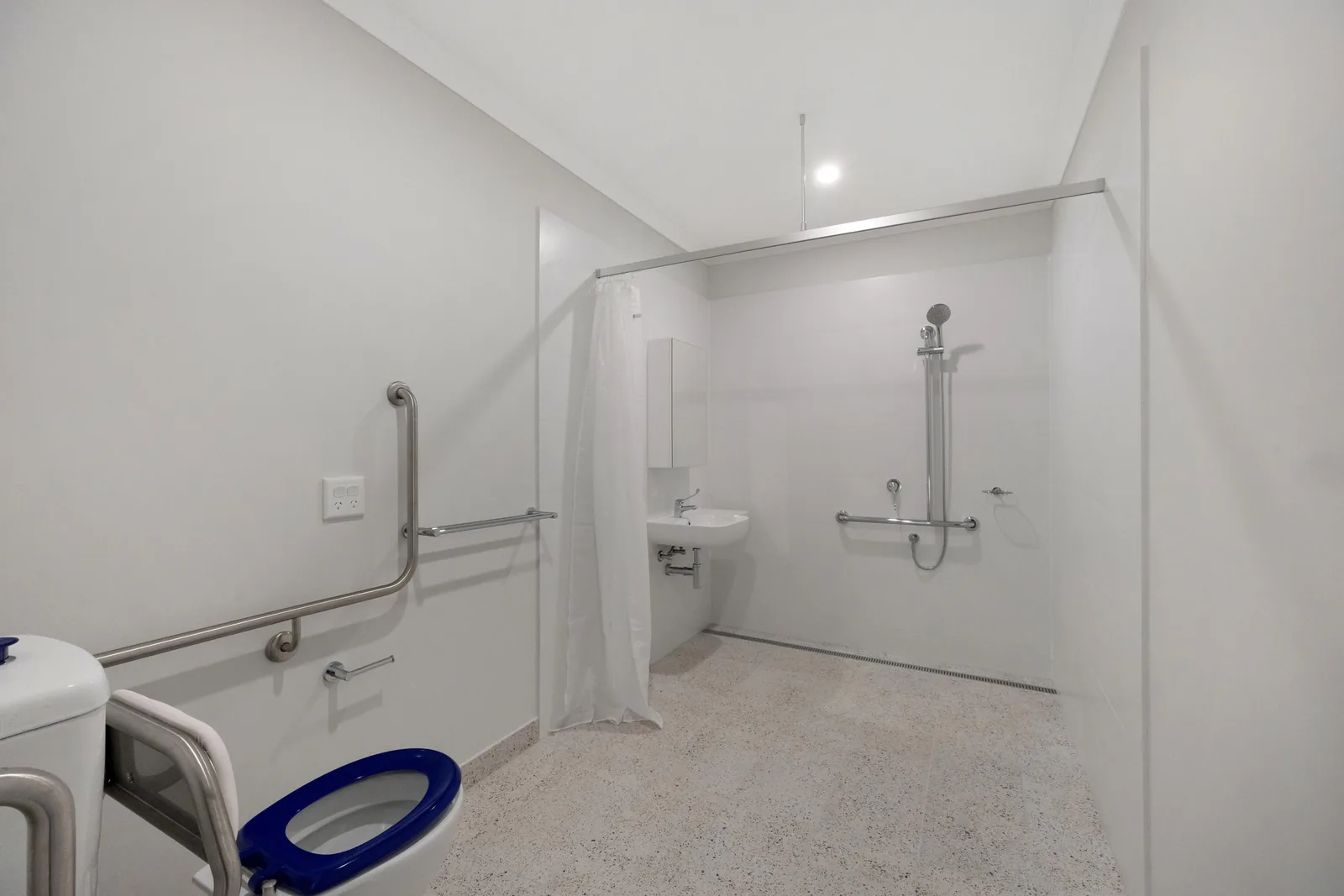 Accessible bathroom with a roll in shower and grab rails